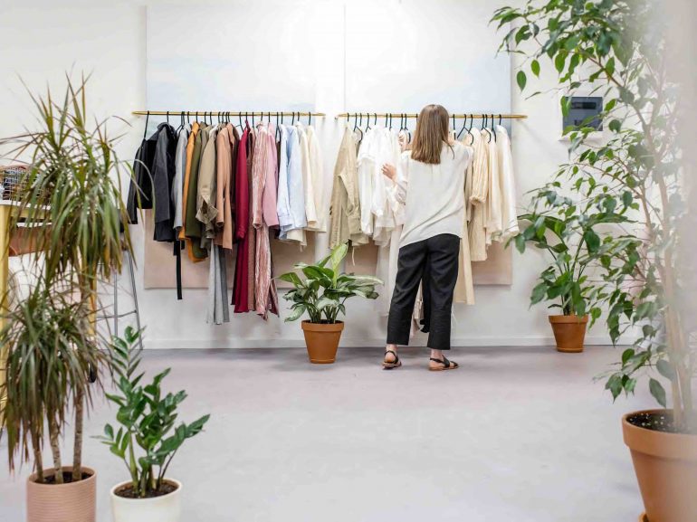 Woman arranging clothes retail store