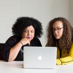 Two Black women using a laptop together