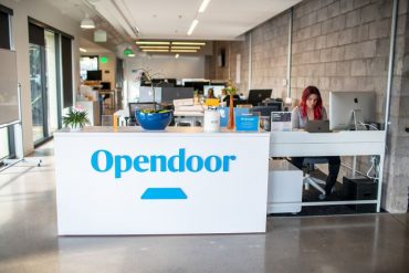 A white desk with Opendoor in blue desk at the front
