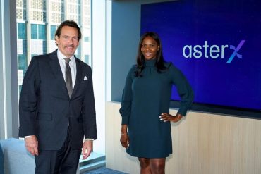 Founders of asterX standing next to each other in front of the asterX logo