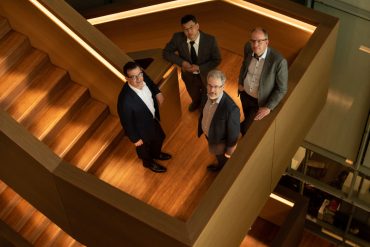 the evolution Q executive team portrait on a dramatic staircase