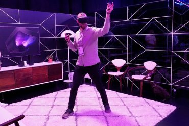 Man using VR headset in a purple room.