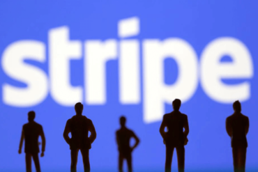 Silouettes of people standing infront of a Stripe logo.