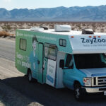 A ZayZoon-branded camper van driving across a US highway.