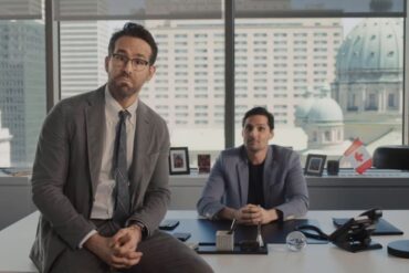 Ryan Reynolds leaning on Nuvei CEO Phil Fayer's desk