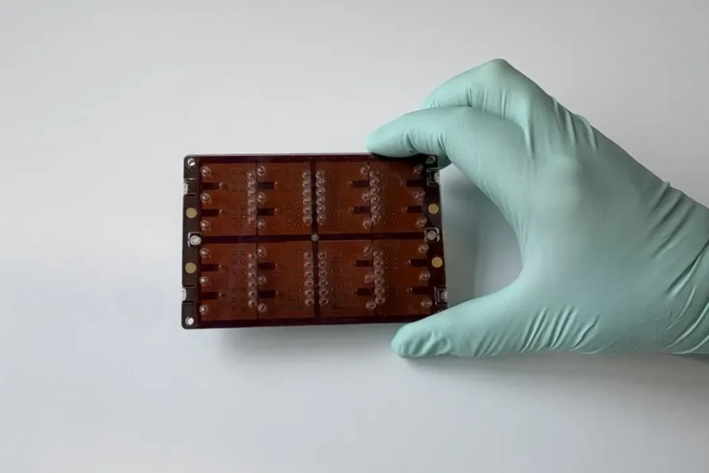 A gloved hand holds a DropGenie chip.